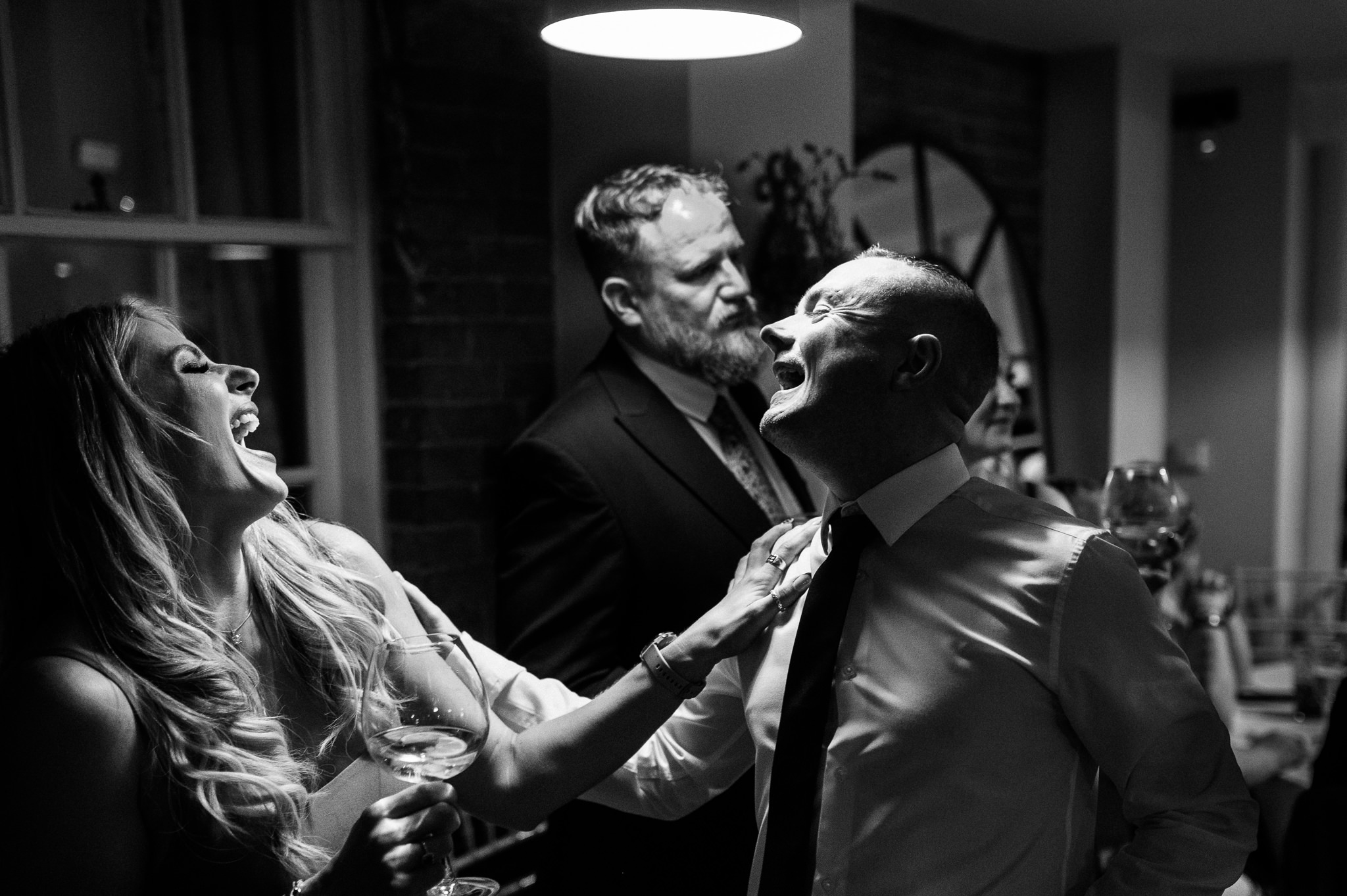 black and white photo of two wedding guests laughing