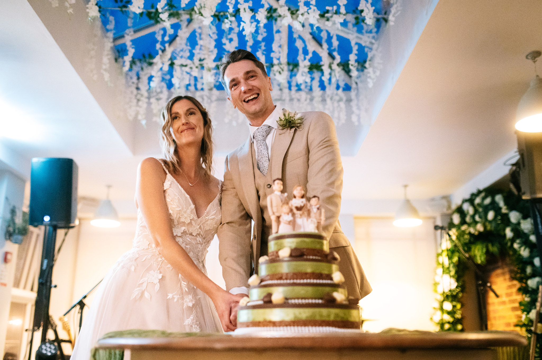 smiling bride and groom cut the wedding cake at kedleston country house
