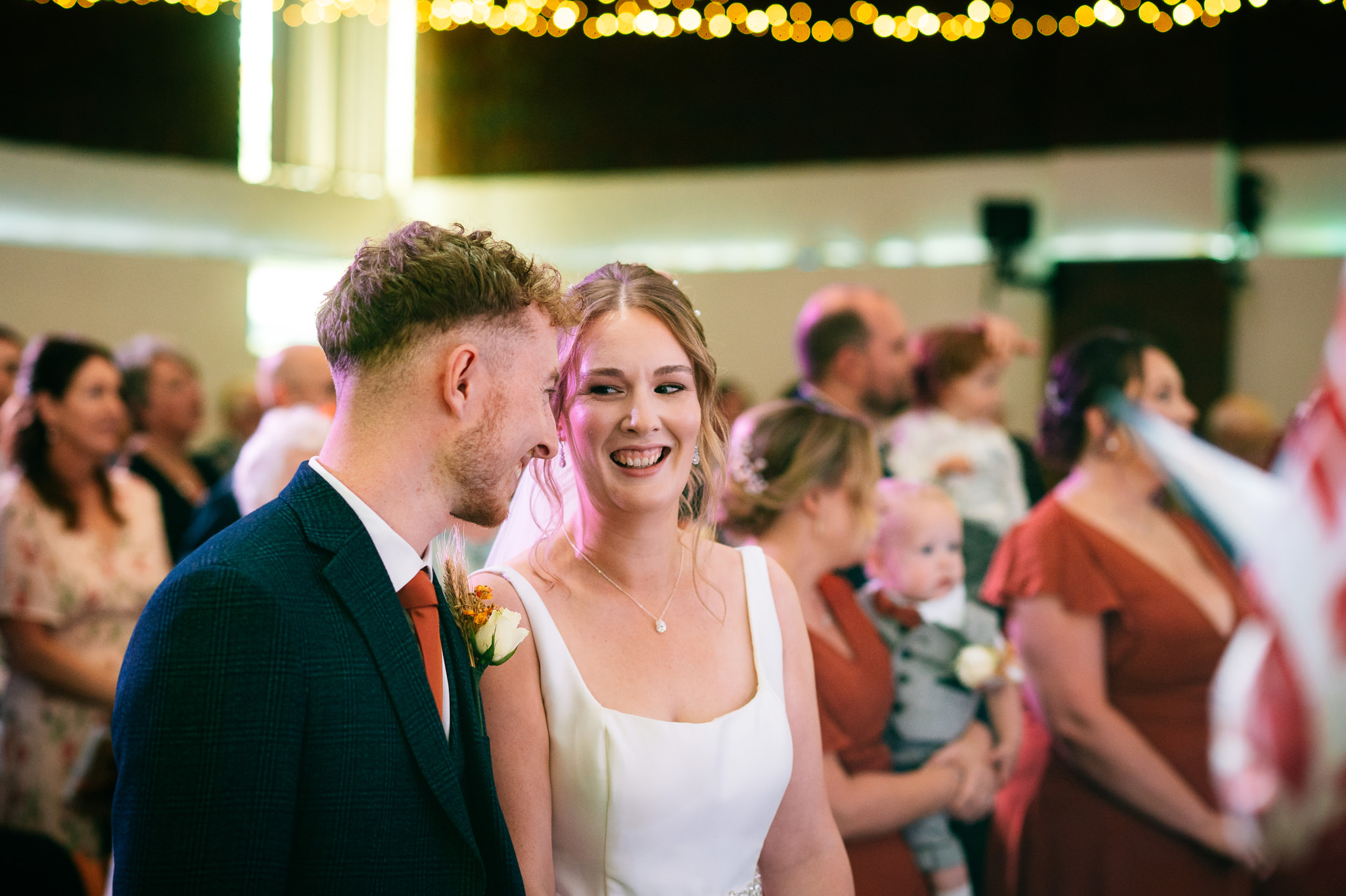 bride in a white dress smiling at her groom during the wedding ceremony