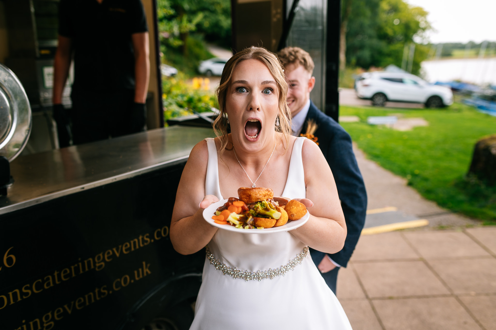 bride pulling a funny shocked face as she holds a plate of roast dinner