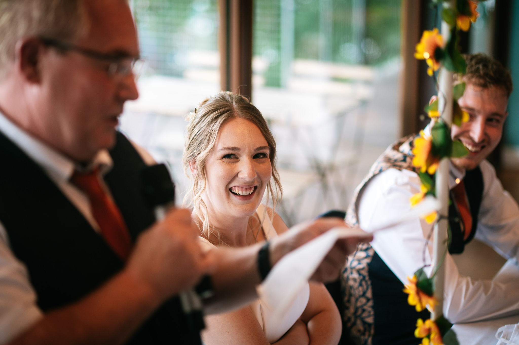 smiling bride looking up at her dad as he gives his wedding speech