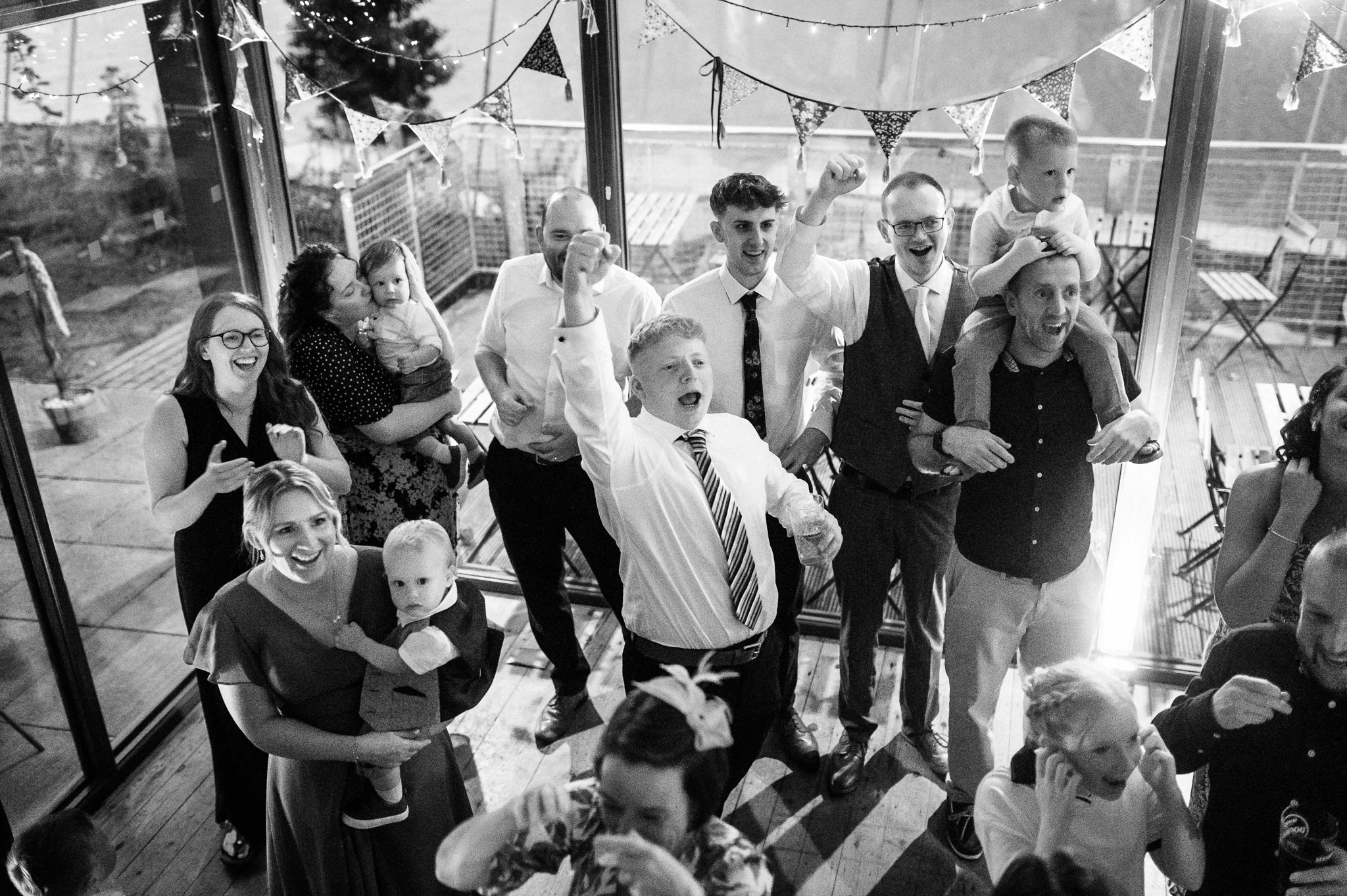 wedding guests cheering and waving on the dance floor
