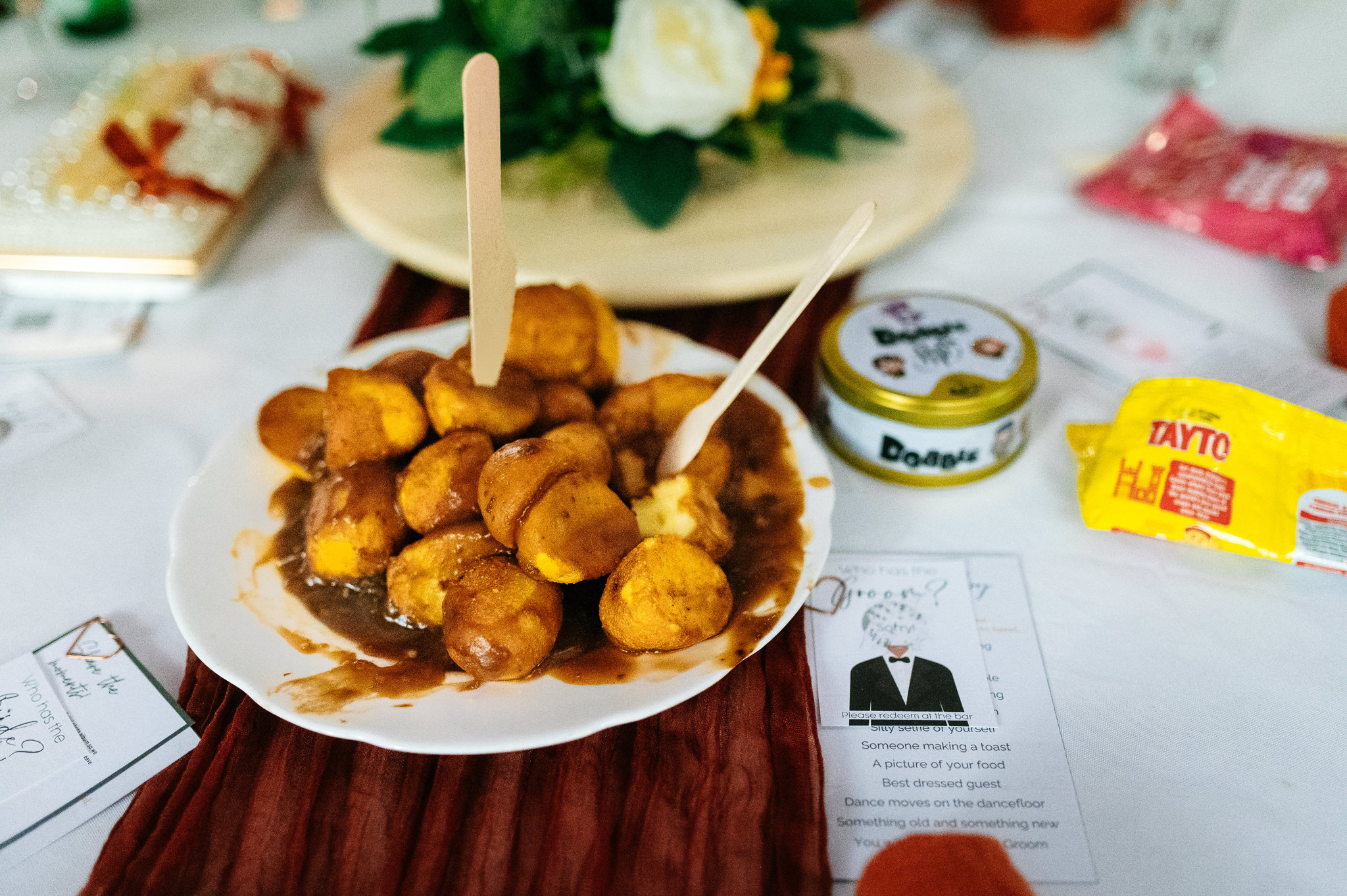 a plate piled high with roast potatoes and gravy with a knife and fork stuck in them