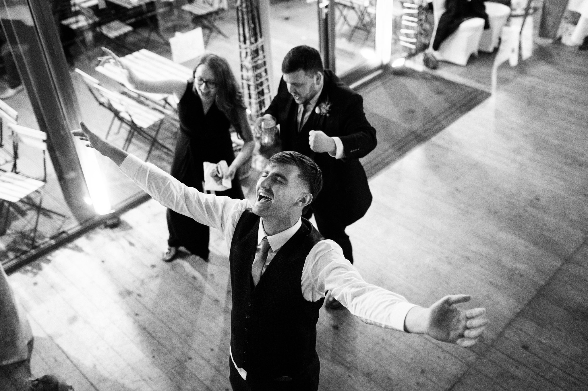 man in a waistcoat dancing with his arms out wide
