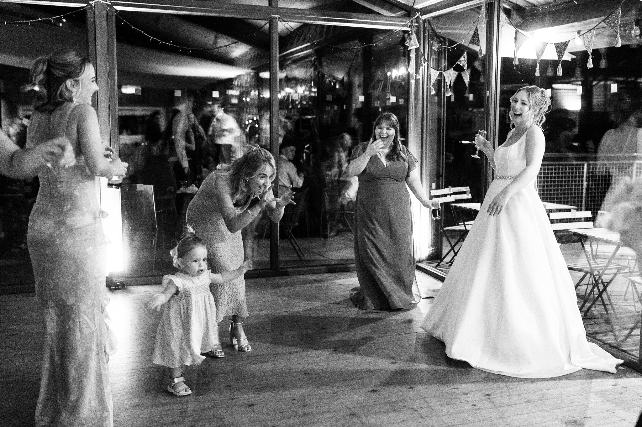 bride laughing with friends on the dance floor