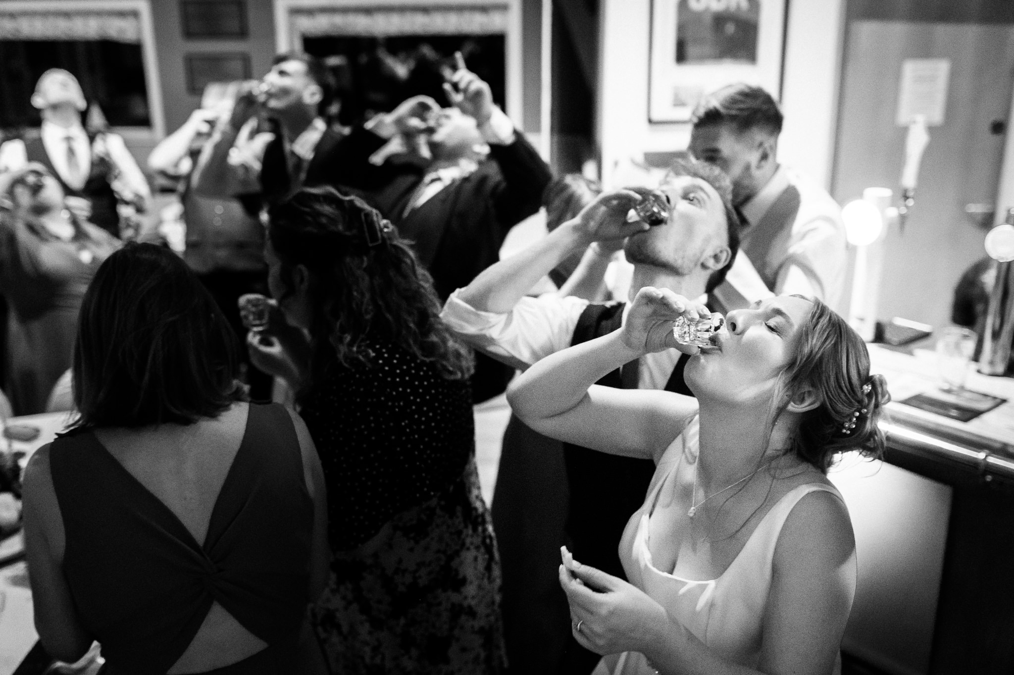 bride and groom doing shots with their guests