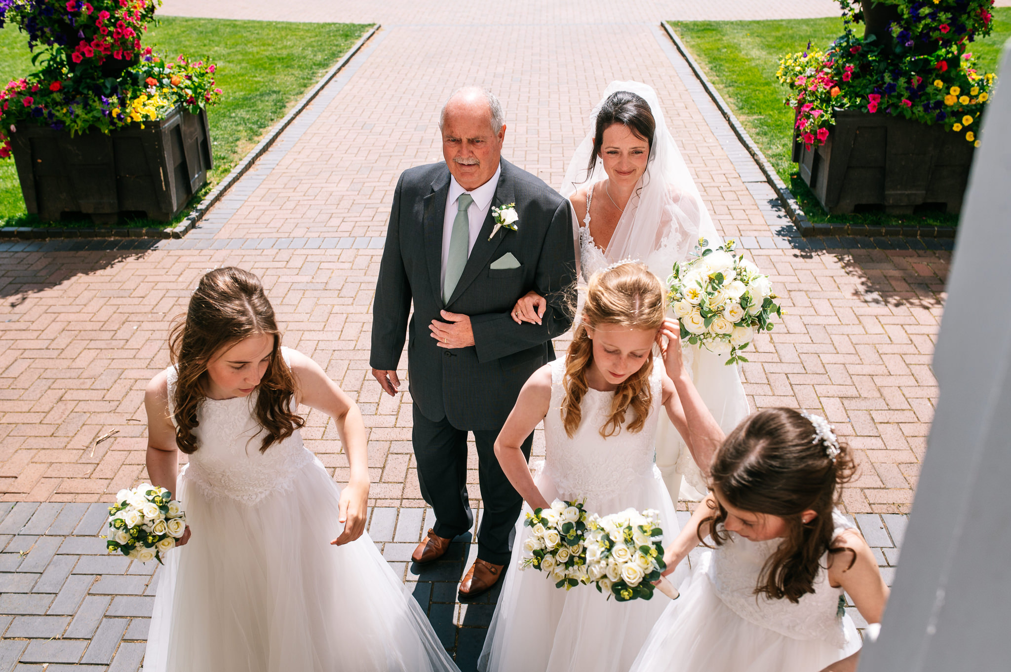 bride arriving at the steps of bridgford hall with her father and her daughters