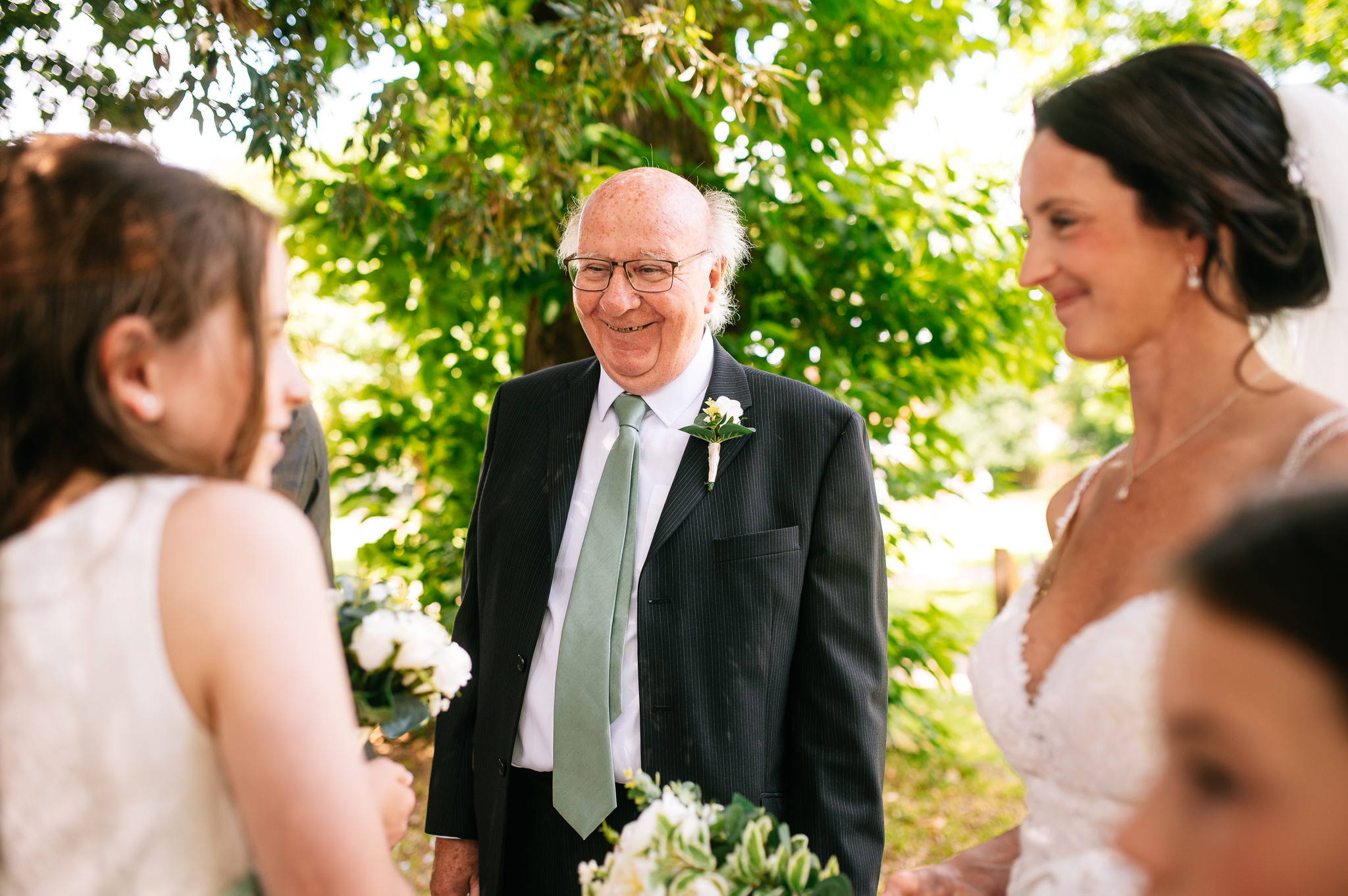 father of the groom smiling with family outside bridgford hall
