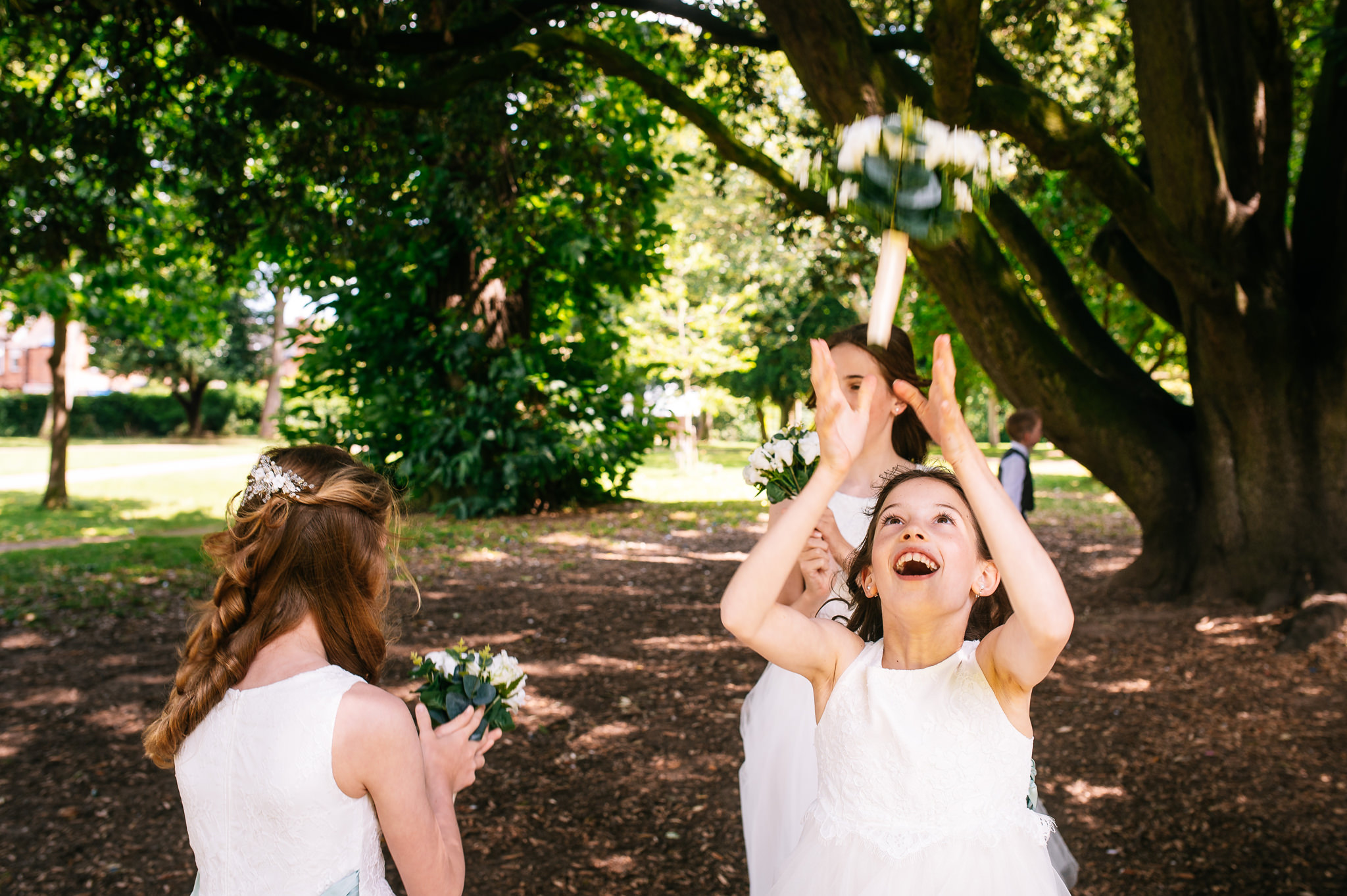 flower girl throwing and catching her bouquet