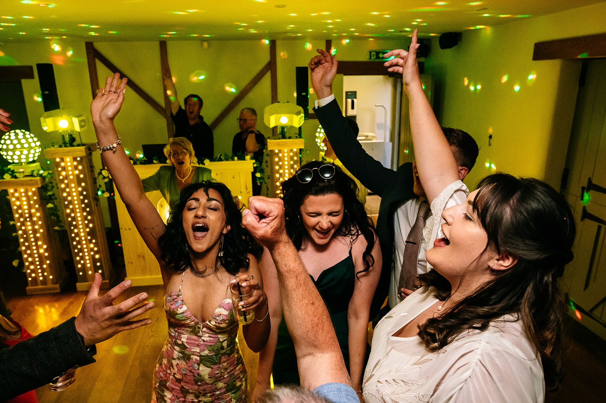 bride with her bridesmaids dancing and cheering on the dance floor