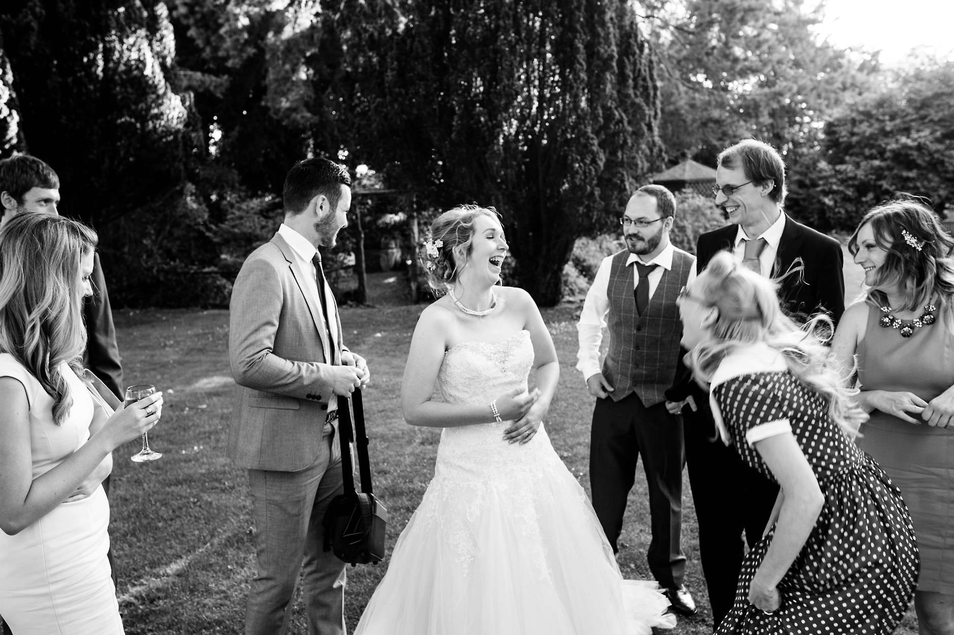 bride laughing with her friends in the grounds of this country house by yorkshire wedding photographer chris seddon