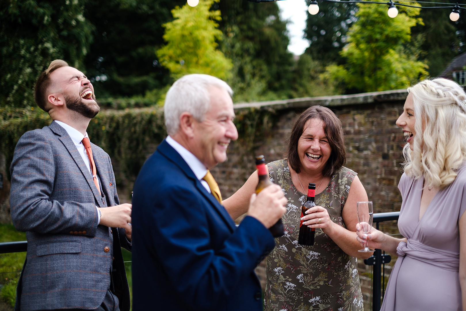 wedding guests laughing captured by a second photographer